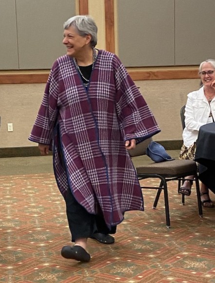 Smiling woman walking in a bold, purple tweed Noh Coat